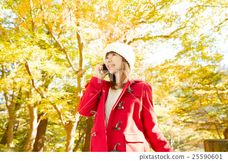 Woman talking on smartphone autumnal leaves background 25590601