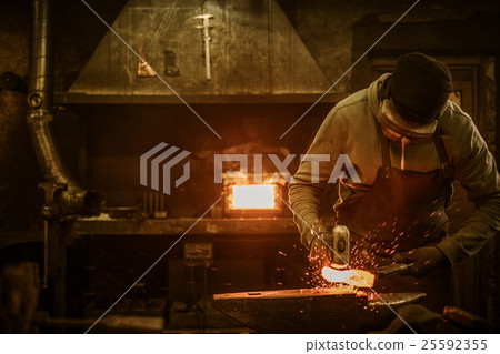 Blacksmith with brush handles the molten metal on Blacksmith with brush handles the molten metal on 25592355