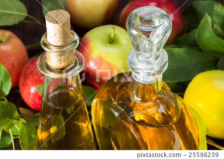 apple cider vinegar in a glass vessel and apples apple cider vinegar in a glass vessel and apples 25598239