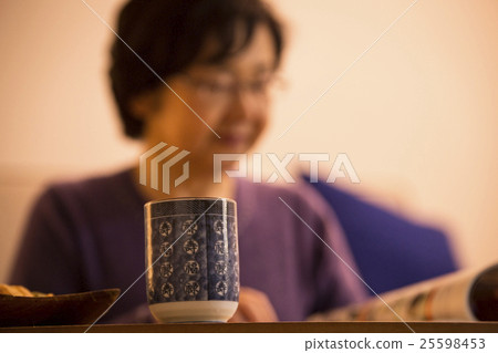 讀雜誌的資深婦女在晚上 25598453