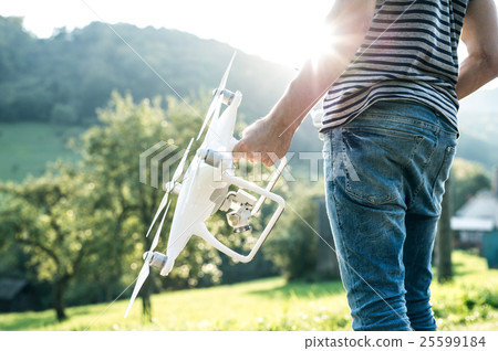 Unrecognizable young man holding drone. Sunny Unrecognizable young man holding drone. Sunny 25599184
