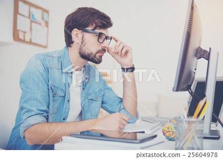 Young programmer looking at computer screen 25604978