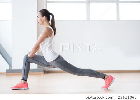 Confident slim woman exercising on a sports hall Confident slim woman exercising on a sports hall 25611063