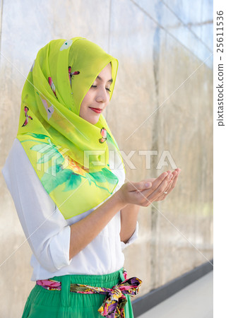 Shot of muslim girl standing , praying portrait Shot of muslim girl standing , praying portrait 25611536