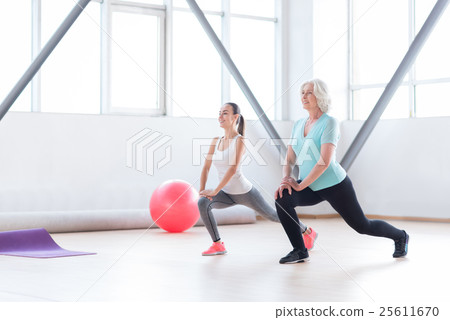 Pleasant slim women doing an exercise Pleasant slim women doing an exercise 25611670