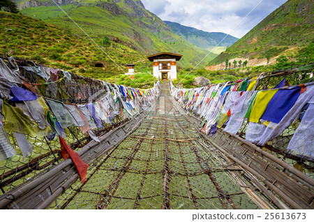 walking suspension bridge with prayer flags 25613673