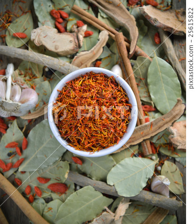 Safflower in the bowl on herbs background 25615822