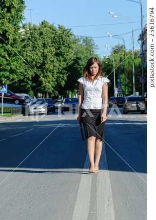 Pretty businesswoman walking on road Pretty businesswoman walking on road 25616794