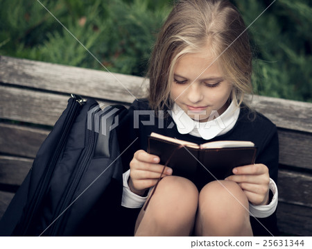 Beautiful blond girl in a school uniform sits on Beautiful blond girl in a school uniform sits on 25631344