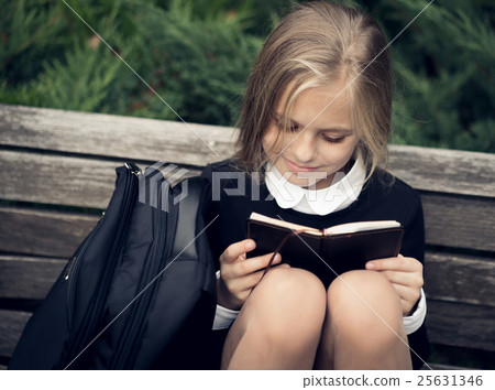 Beautiful blond girl in a school uniform sits on Beautiful blond girl in a school uniform sits on 25631346