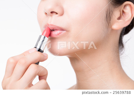 A woman applying lipstick 25639788