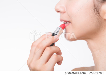 A woman applying lipstick 25639789