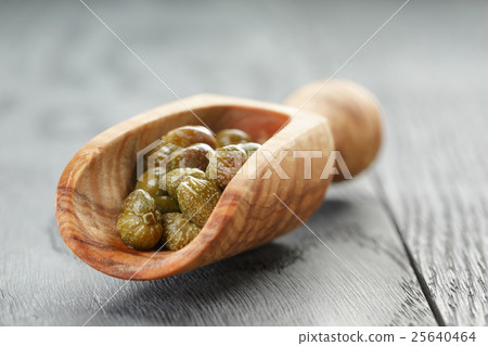 marinated capers in wood scoop on table marinated capers in wood scoop on table 25640464