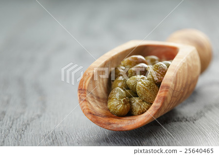marinated capers in wood scoop on table marinated capers in wood scoop on table 25640465