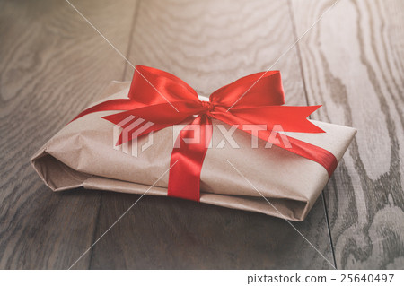 rustic present box with red ribbon on wood table rustic present box with red ribbon on wood table 25640497