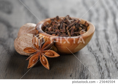 anise stars cloves and nutmeg in olive bowl on oak table, rustic anise stars cloves and nutmeg in olive bowl on oak table, rustic 25640504