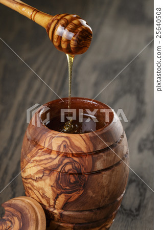 maple honey flowing from dipper to pot, rustic maple honey flowing from dipper to pot, rustic 25640508