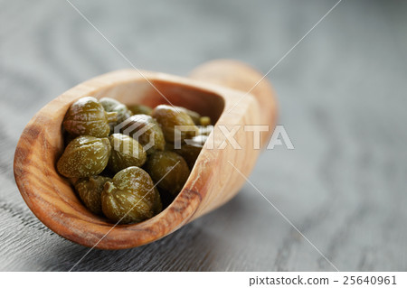 marinated capers in olive scoop on wood table marinated capers in olive scoop on wood table 25640961