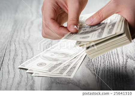 young female hands count dollar bills on table 25641310