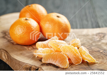 ripe tangerines peeled on wood table 25641552