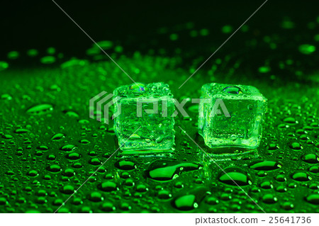 ice cubes on lighting green background. 25641736
