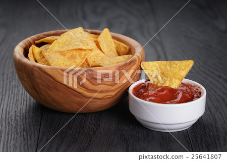 tortilla chips in olive wood bowl on wooden table 25641807