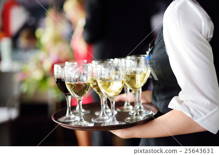 Waitress with dish of champagne and wine glasses Waitress with dish of champagne and wine glasses 25643631