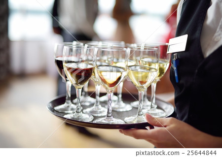 Waitress with dish of champagne and wine glasses 25644844