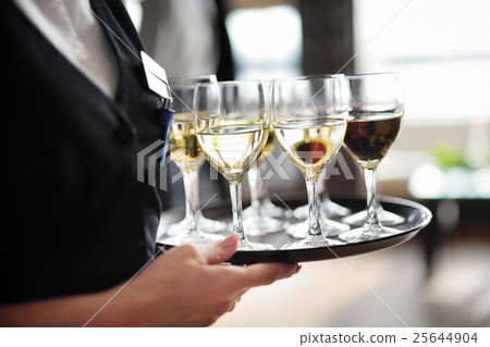 Waitress with dish of champagne and wine glasses 25644904
