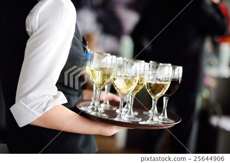 Waitress with dish of champagne and wine glasses 25644906