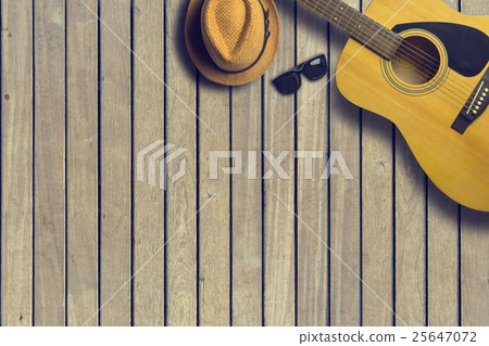 Acoustic guitar with hat and sunglasses on wooden Acoustic guitar with hat and sunglasses on wooden 25647072