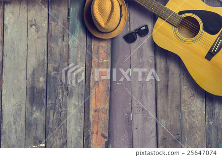 Acoustic guitar with hat and sunglasses on wooden Acoustic guitar with hat and sunglasses on wooden 25647074