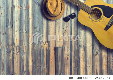 Acoustic guitar with hat and sunglasses on wooden Acoustic guitar with hat and sunglasses on wooden 25647075
