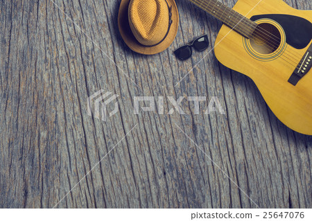 Acoustic guitar with hat and sunglasses on wooden Acoustic guitar with hat and sunglasses on wooden 25647076