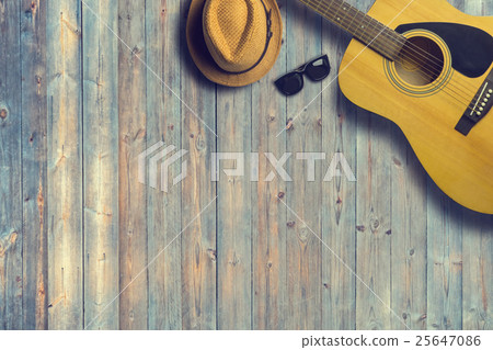 Acoustic guitar with hat and sunglasses on wooden Acoustic guitar with hat and sunglasses on wooden 25647086