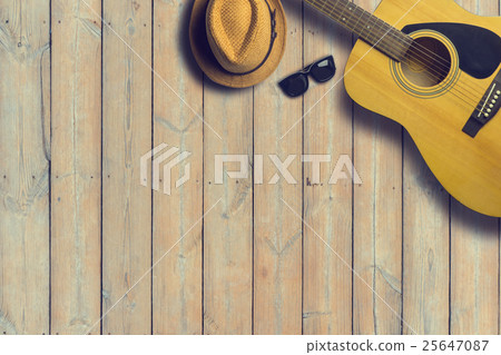 Acoustic guitar with hat and sunglasses on wooden Acoustic guitar with hat and sunglasses on wooden 25647087
