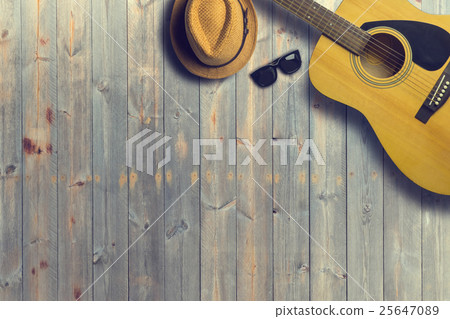 Acoustic guitar with hat and sunglasses on wooden Acoustic guitar with hat and sunglasses on wooden 25647089