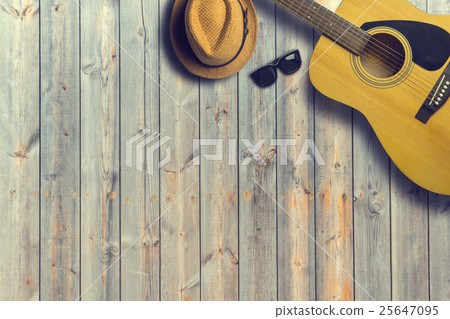Acoustic guitar with hat and sunglasses on wooden Acoustic guitar with hat and sunglasses on wooden 25647095