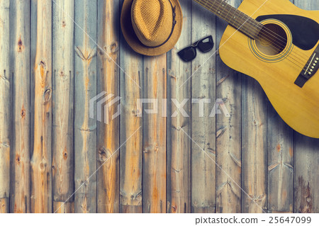 Acoustic guitar with hat and sunglasses on wooden Acoustic guitar with hat and sunglasses on wooden 25647099