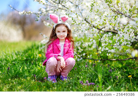 Adorable little girl in blooming cherry garden 25649386