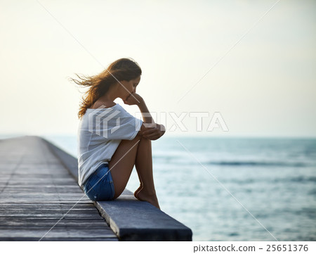 Sad lonely beautiful woman sitting on the pier Sad lonely beautiful woman sitting on the pier 25651376