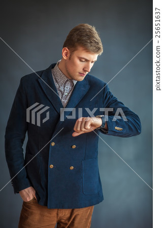 Handsome young man looking at his watch 25651637