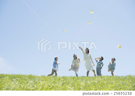 Elementary school students and teachers who fly paper airplanes in the meadow 25655238