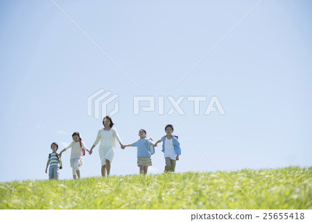 Elementary school students and teachers holding hands in the field Elementary school students and teachers holding hands in the field 25655418