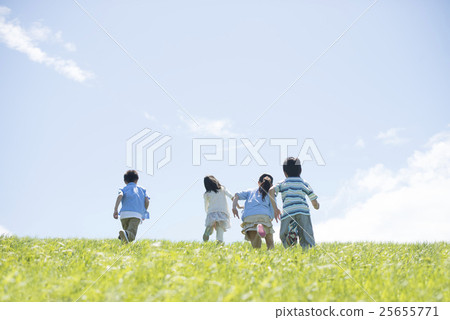Rear appearance of elementary school student running on grassland Rear appearance of elementary school student running on grassland 25655771