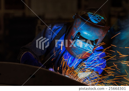 Welder in action welding metal in factory 25668301