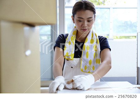 A woman who opens a moving box 25670820