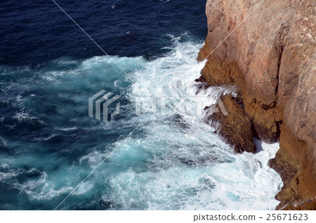strong waves in blue sea splashing on rocks strong waves in blue sea splashing on rocks 25671623