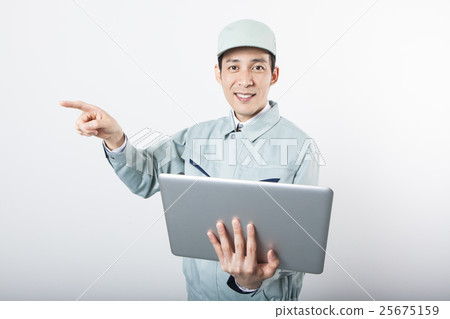 A man with work clothes that holds a personal computer and touches his finger A man with work clothes that holds a personal computer and touches his finger 25675159