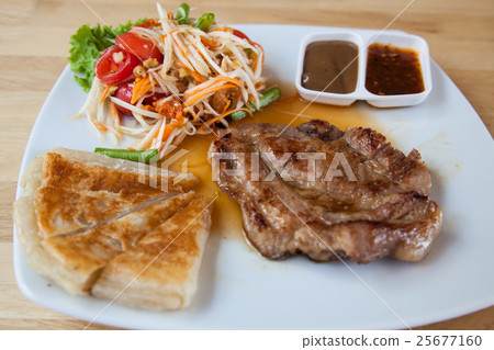 Pork steak with roti and Thai papaya salad. Pork steak with roti and Thai papaya salad. 25677160